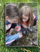 Smilla und Emmi haben eine Köcherfliegenlarve in ihrer Becherlupe gefangen